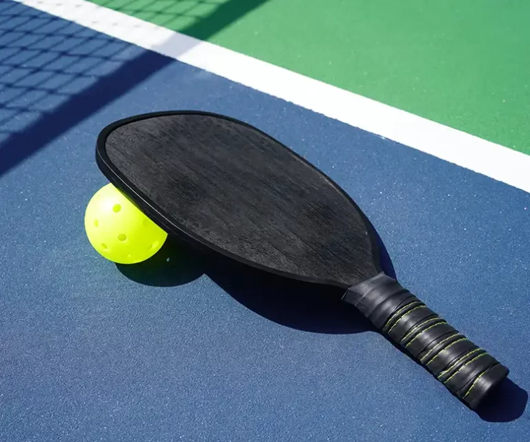 Pickleball Racket and Ball on an Outdoor Court